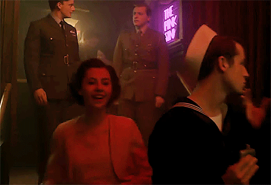 Margaret finds her sister, watches Elizabeth let her hair down, and swigs alcohol from a random sailor's flask on her way to join her on the dance floor.